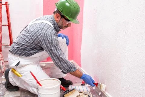 House painter worker at work in the construction site. Building. Stock Photos