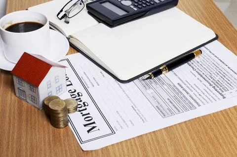 House paper with coins stack on mortgage application form on worktable 写真素材
