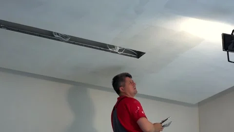 House refurbishment. Worker spackling ceiling with putty Stock Footage 147370586