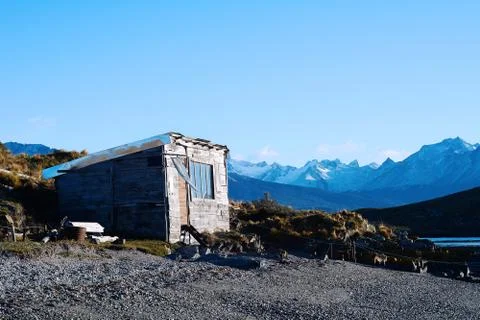 House on river with mountains at back. Stock-Fotos