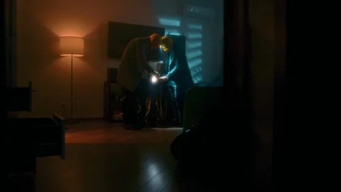 House robbery by two masked thieves searching cabinets for valuables Stock Footage 312985579