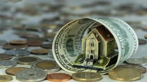 A house in a rolled up banknote Stock Photos