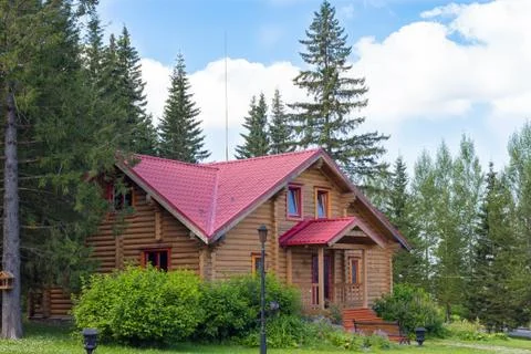 House of round logs between trees Stock Photos