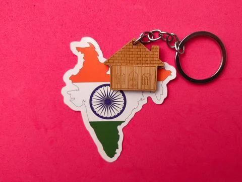 A house-shaped keychain is placed over an India map sticker on a vibrant pi.. Fotos Stock
