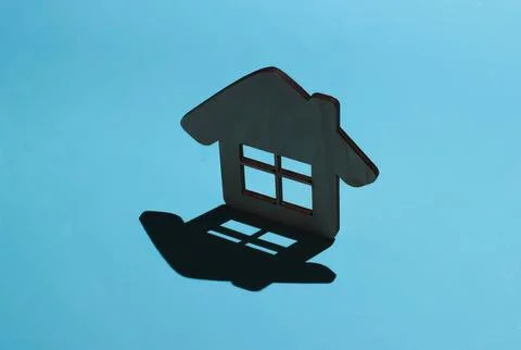 House-shaped shadow on blue background Stock Photos