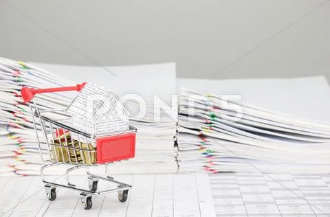House in shopping cart with gold coins on finance account Stock Photos