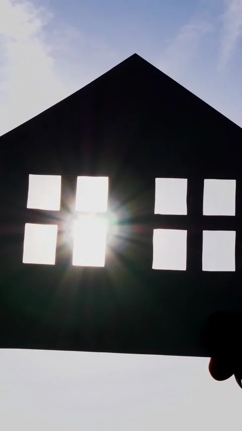 House silhouette with sunlight shining through windows against blue sky Stock Footage 343993502