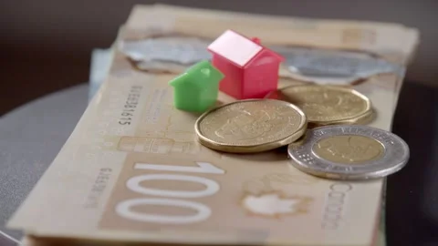 House on stack of Canadian dollars rotating in circle, Canadian Banknotes Money Stock Footage 266340469