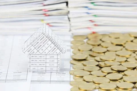 House with stack of gold coins on another side Stock Photos