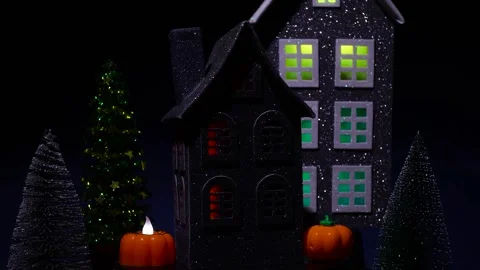 A house surrounded by glowing pumpkins and a candle rotates against Stock Footage 318916973