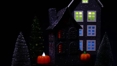 House surrounded by glowing pumpkins rotates against of a large black house Stock Footage 319293896