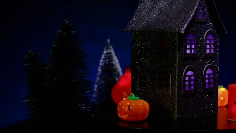 A house surrounded by glowing pumpkins of various shapes, rotates Stock Footage 319263227