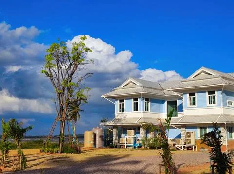 House surrounded by trees and clouds in a rural area during the day. Pak Ha.. Stock Photos