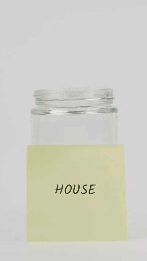 House Text or word on yellow sticky note attached to glass jar with hand Stock Footage 311742287
