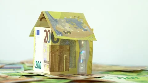 House on top of a large stack of money bills. Real estate mortgage concept shot. Vidéo 145279555