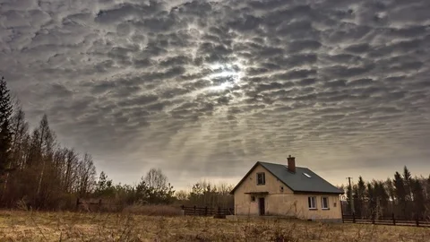 House under cloudy sky and sun at morning. 4k timelapse. Video stock 79614148