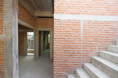 House under construction with red brick wall and stair Stock Photos