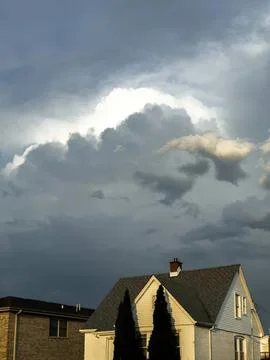 House under dark cloudy sky with storm clouds overhead Stock Photos