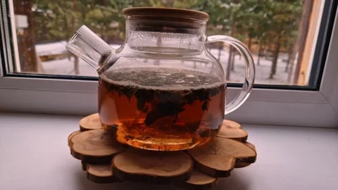 In the house by the window against the backdrop of snowfall there is a kettle Stock Footage 262637812