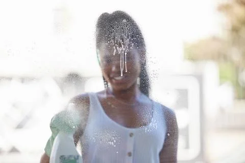 House work, window cleaning and black woman with bottle to spray soap while Stock Photos