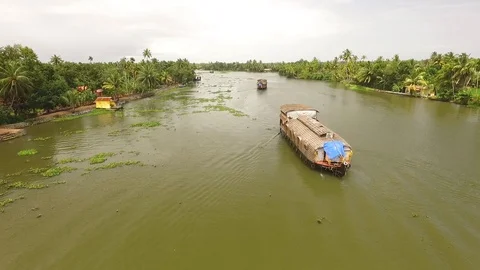 A houseboat is seen sailing down a river in Kerala, India. Stock Footage 129443927