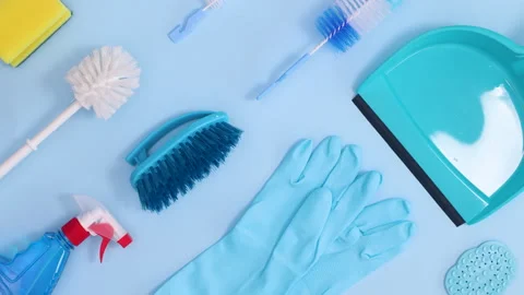 Household cleaning tools make creative pattern on blue background. Stop motion Stock Footage 151426214