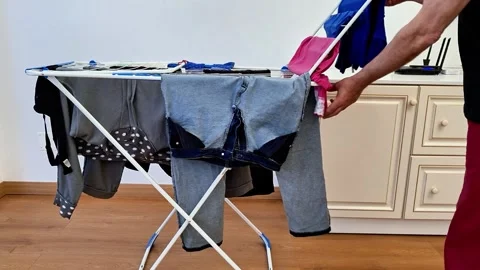 Household Laundry Drying on Folding Clothes Rack Stock Footage 338317564