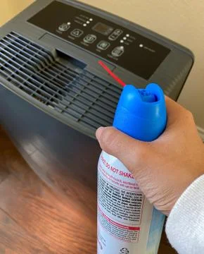 Household using the air duster to clean the air vent of dehumidifier Stock Photos