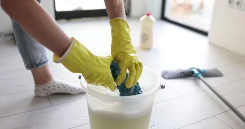 Housekeeper in gloves washes microfiber mop in soapy bucket Stock Footage 312156370