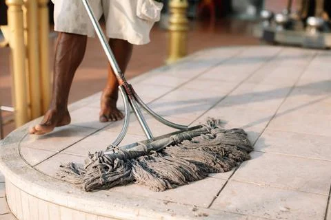 ?Housekeeper mopping the floor with a mop and cleaning products to clean du.. Stock-Fotos