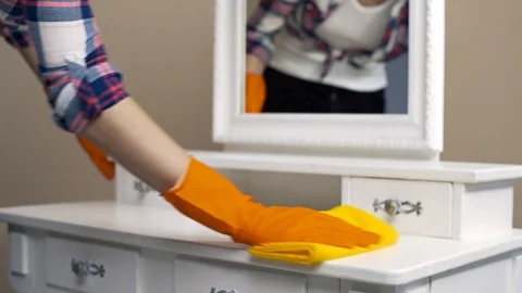 Housekeeper in rubber gloves dusting the surfaces in the room with special Stock Footage 100961954