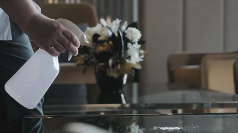 The housekeeper sprays detergent on the table surface. Stock-Footage 221706912
