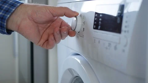 Housekeeper Using a Laundry Machine Set the Program and Push Start Button Stock Footage 125447527