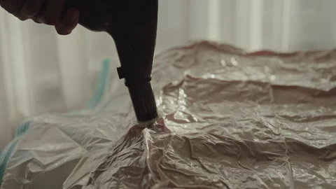 Housekeeper using vacuum cleaner to remove air from space saver compression bag Stock Footage 304874567