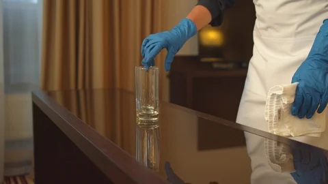 Housemaid in gloves wipe the table with rag in hotel room Stock Footage 121932809