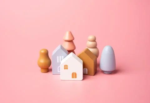Houses and tree figures on a pink background. Affordable housing. Buying a ni Stock Photos