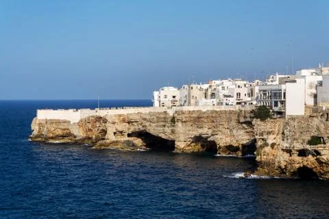 Houses on dramatic cliffs over Adriatic sea in Polignano a Mare, Italy, sunny 库存照片