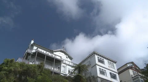 Houses on a hill and fast clouds time lapse Stock Footage 1034337