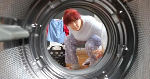 Housewife drinking wine while doing the laundry. View from the washing machin Stock-Footage 152855349