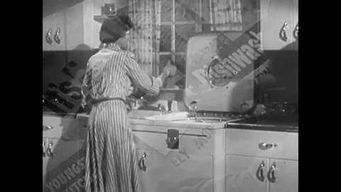A housewife loads an automatic dishwasher in the 1950s. Stock Footage