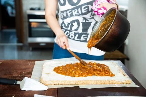 Housewife in process of baking delicious rectangular brittle in kitchen - spread Stock Photos