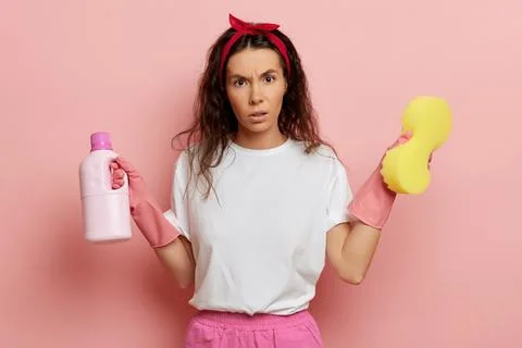 Housewife with unexpected emotion at the face, holds goods for cleaning Stock Photos