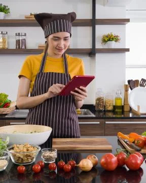 The housewife using tablet computer to find recipes on the internet. Stock Photos