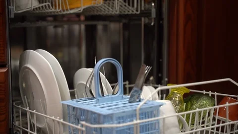 Housewife's hand loading washer's basket with dirty dishes. Cleaning concept Stock Footage 123085476