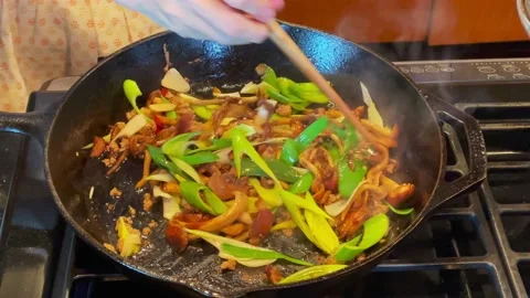 Housewives are using a flat iron wok to fry vegetables Video stock 169937414