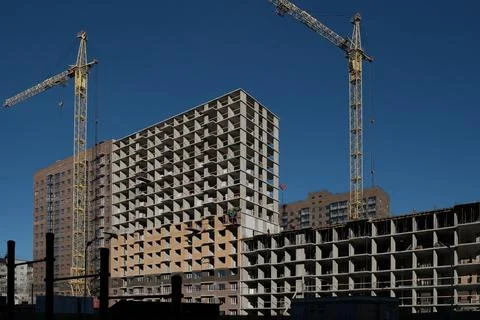 Housing construction of a new area in the city, a construction crane on a blue Stock Photos
