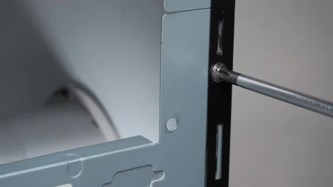 From the housing of the system unit, using a screwdriver, Unscrew the bolt Stock Footage 131095073