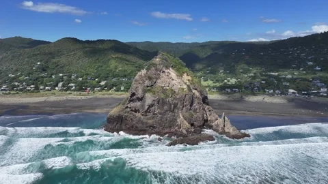 Hover in front of Lion Rock, a rocky headland, located on Piha Beach  Stock Footage 328345324