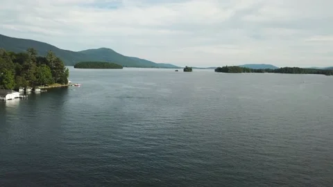 Hover over a large lake with nearby islands and tree covered hills-aerial Stock Footage 161487522