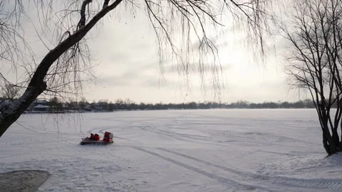 Hovercraft driving at high speed on snow covered frozen ice surface of lake Stock Footage 326774783